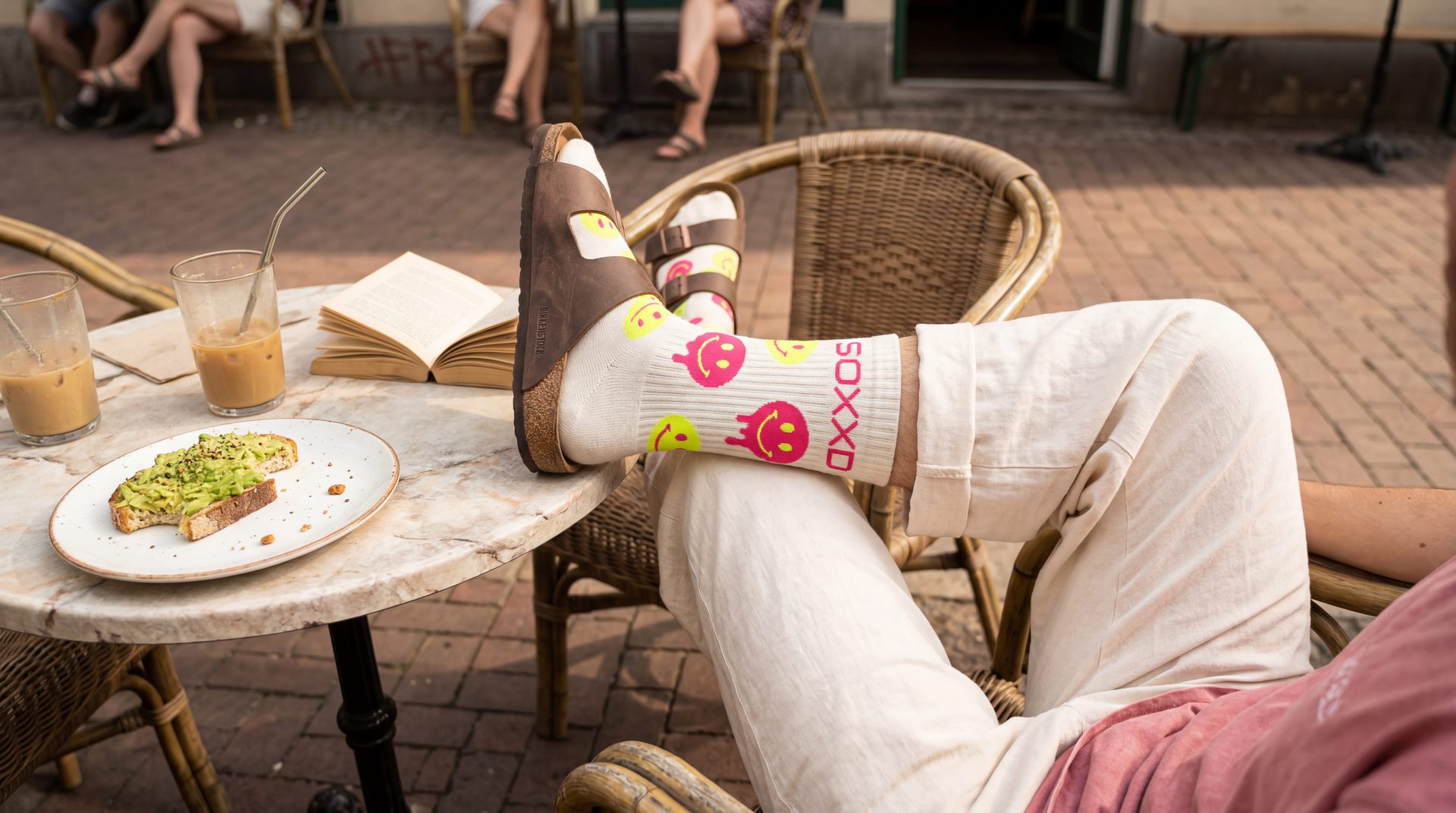 Feet up at a Berlin café — smiley-pattern SOXXD socks in Birkenstocks.