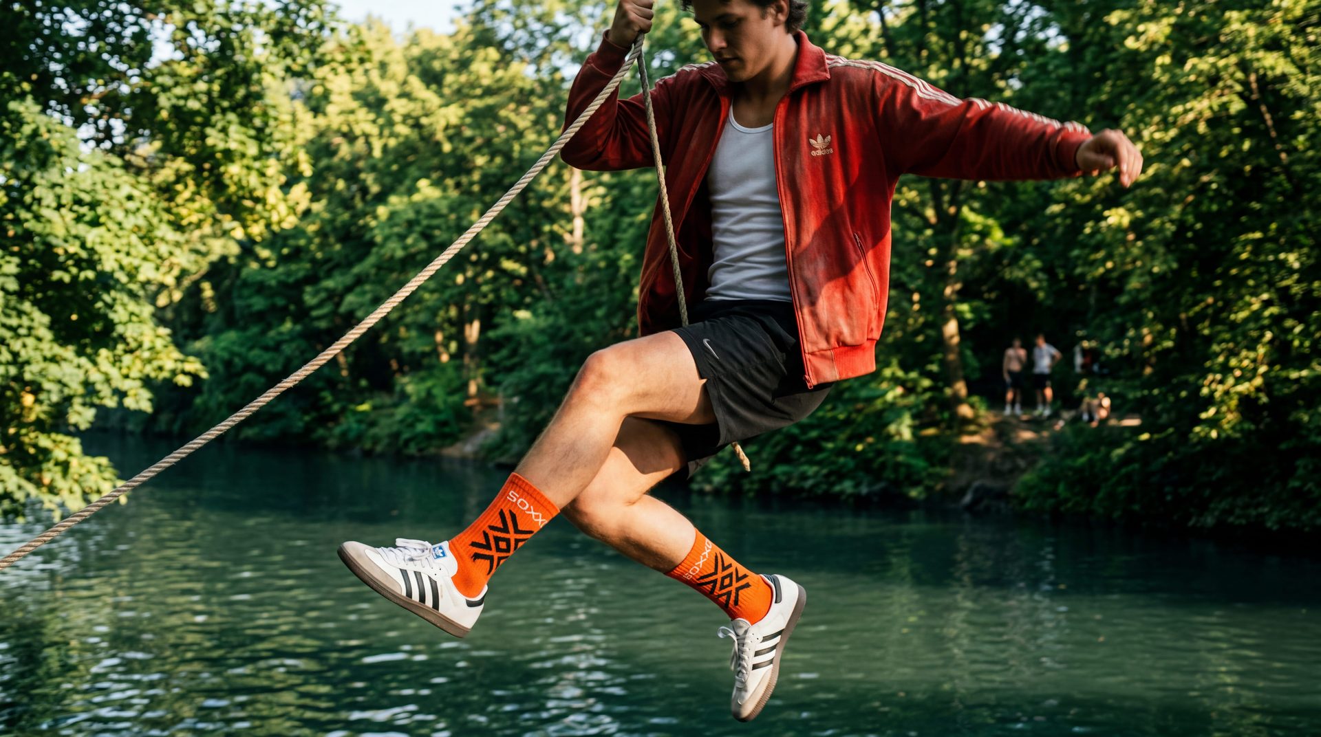 Tracksuit kid swinging on a rope over a Berlin canal in SOXXD socks.